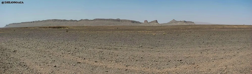 Sahara met de pieken van het Anti-Atlas gebergte op de achtergrond